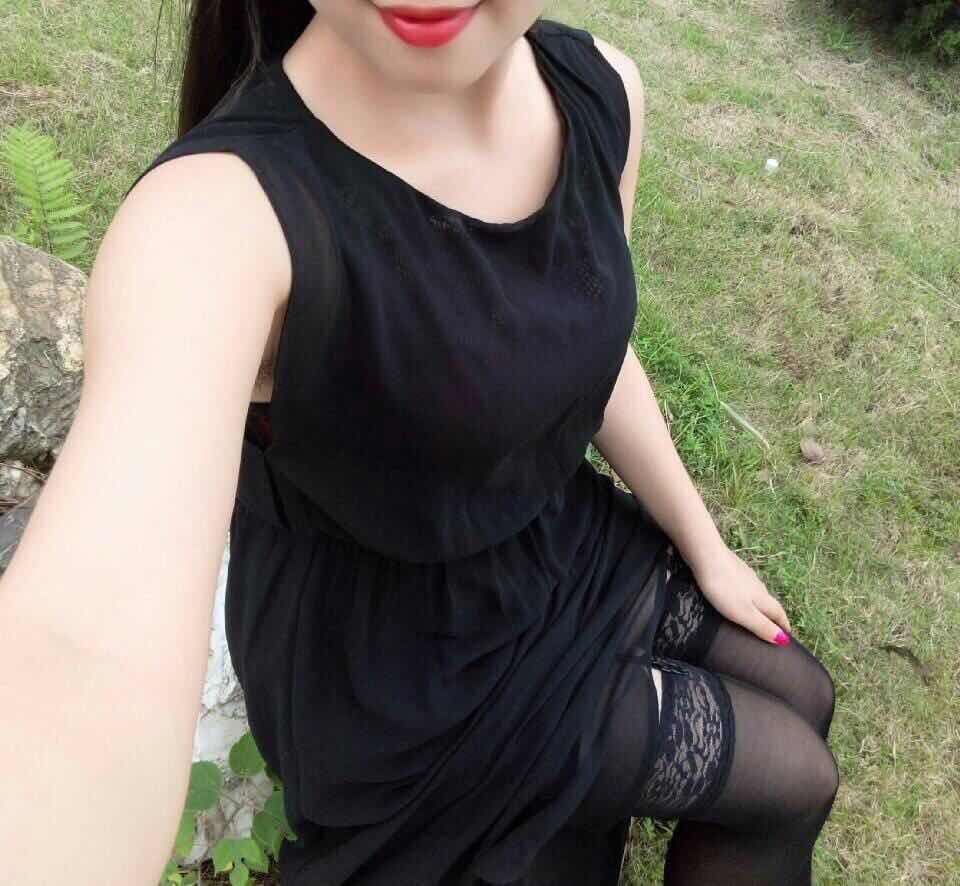 Park portrait with model in a strap top and long black pantyhose seated on a wooden bench